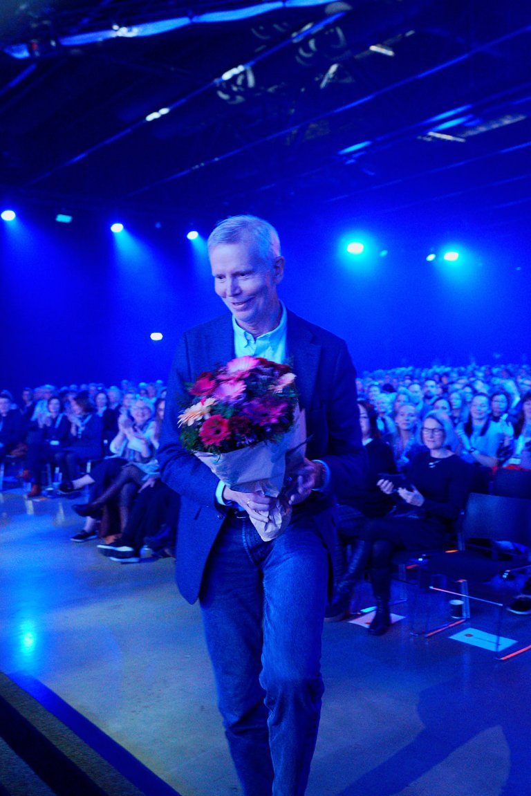 Mann mottar pris og blomster